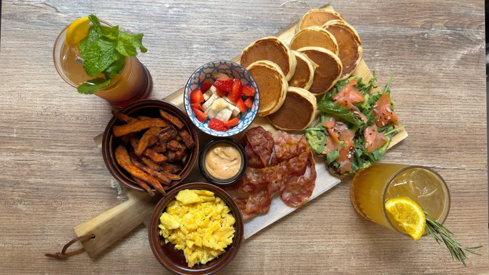 Il Brunch Traveler con pancakes, bacon, uova, avocado toast al salmone e due drink