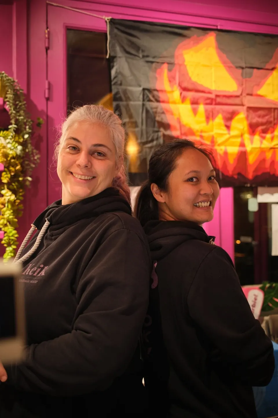 Lo staff di KEIK con le felpe del locale davanti a un allestimento di Halloween