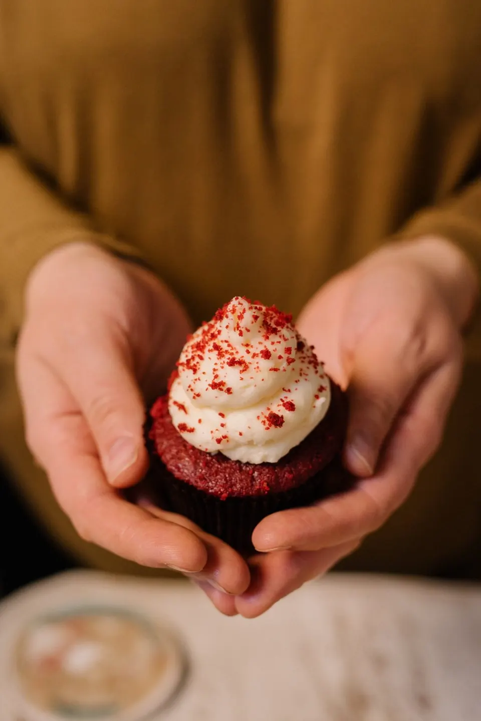 Un cupcake Red Velvet tenuto tra le mani