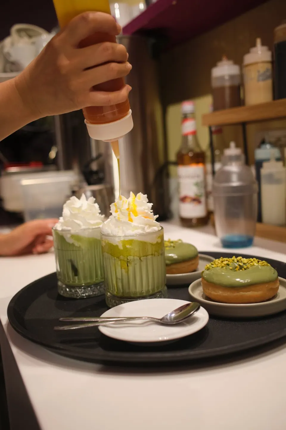 Matcha freddi con panna e donut al pistacchio preparati al banco